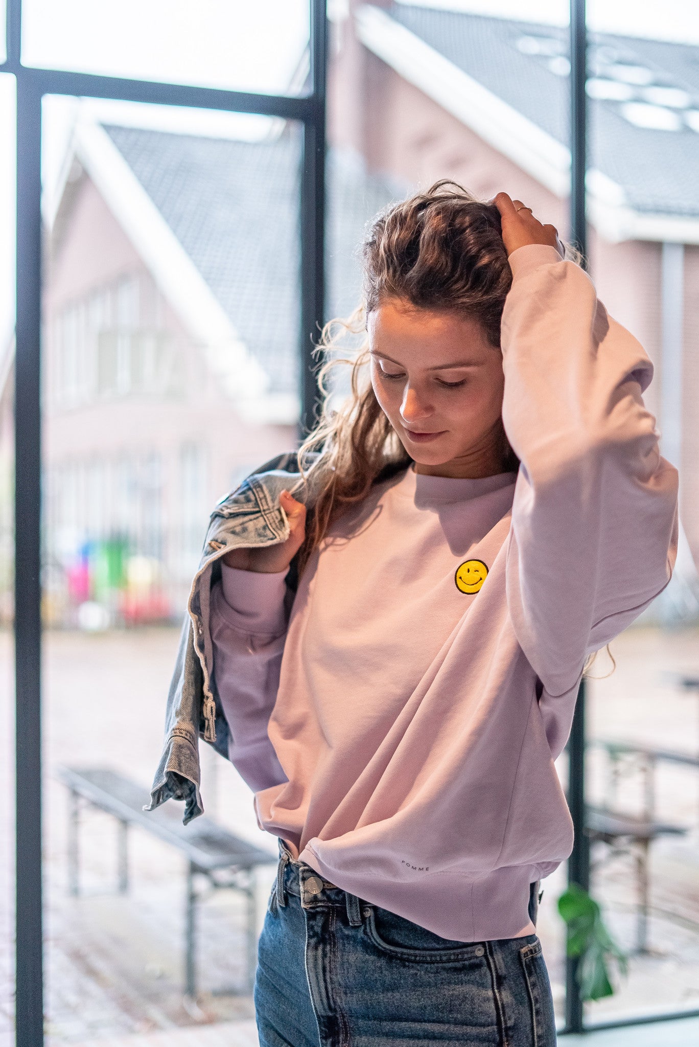 Vrouw in oversized lila trui met smiley gepersonaliseerd. 