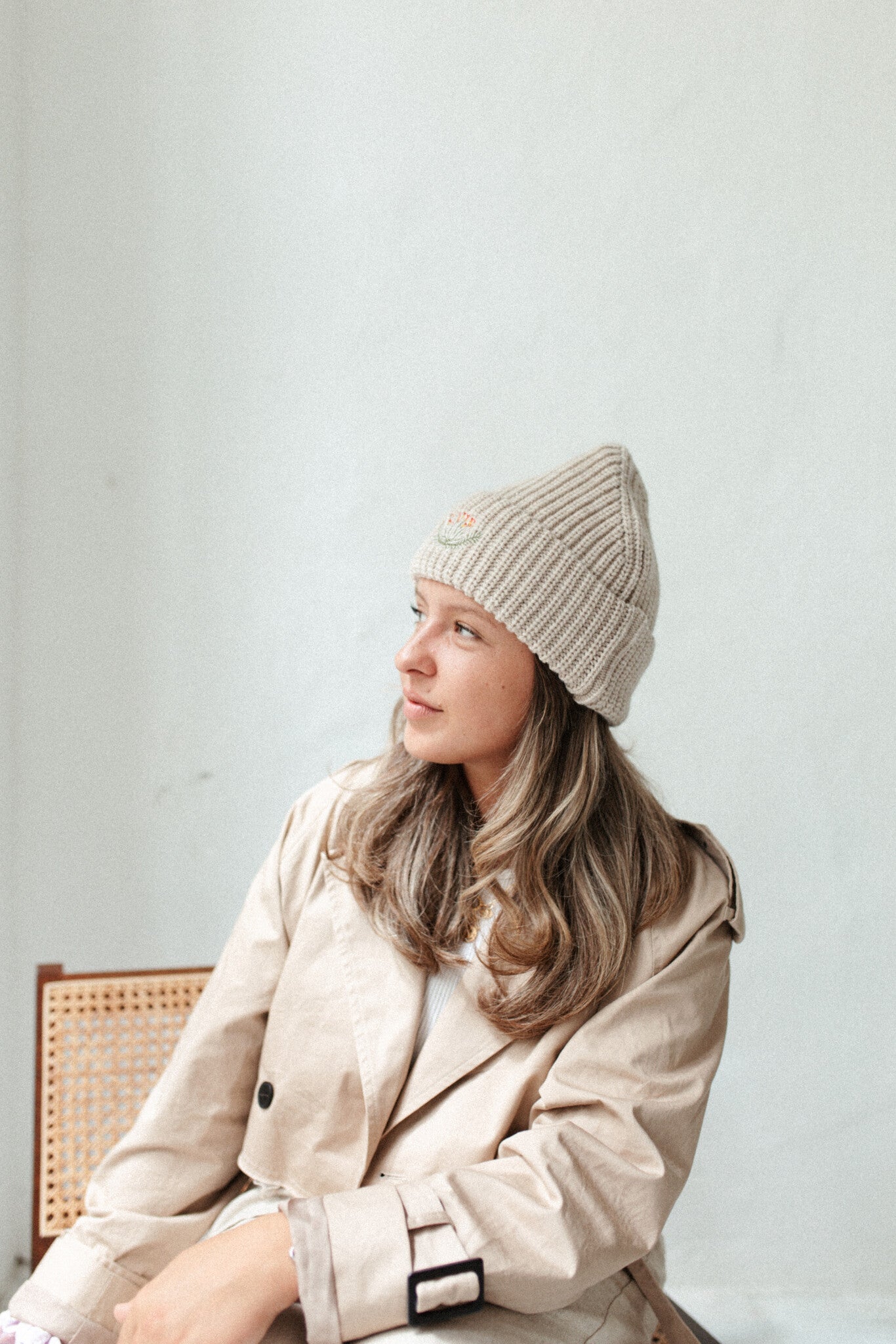 Vrouw met beige gebreide muts, trendy accessoire voor dames.